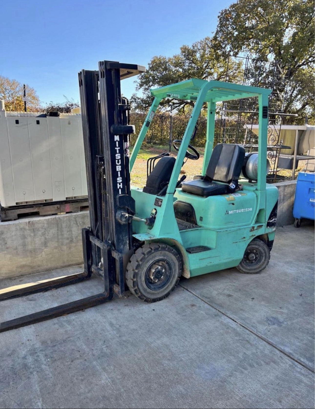 Small Mitsubishi warehouse forklift that may be underused or no longer part of daily operations